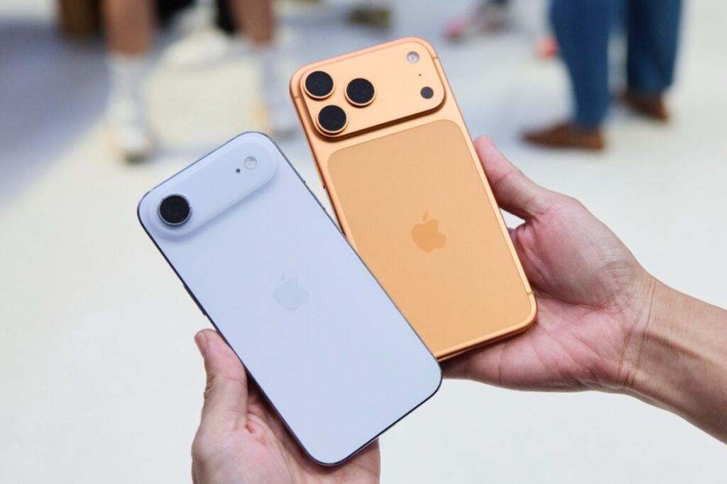 Dwa telefony Apple trzymane w ręce